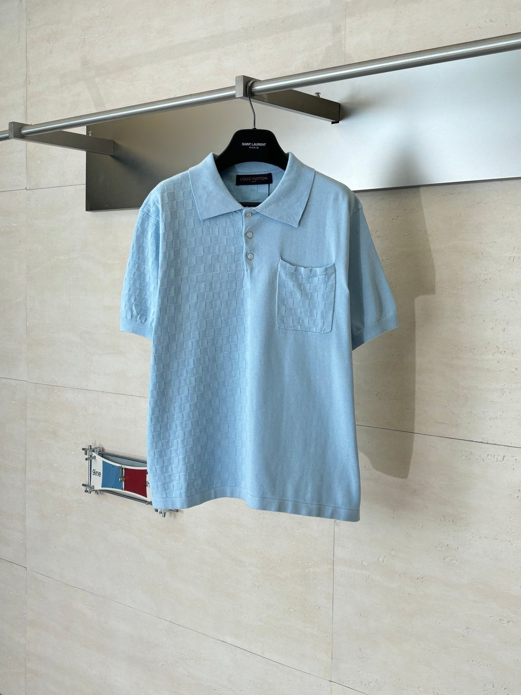 Light blue polo shirt with short sleeves, collar, button placket, and chest pocket