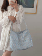 Light blue patterned crossbody tote bag with zip-top and short strap
