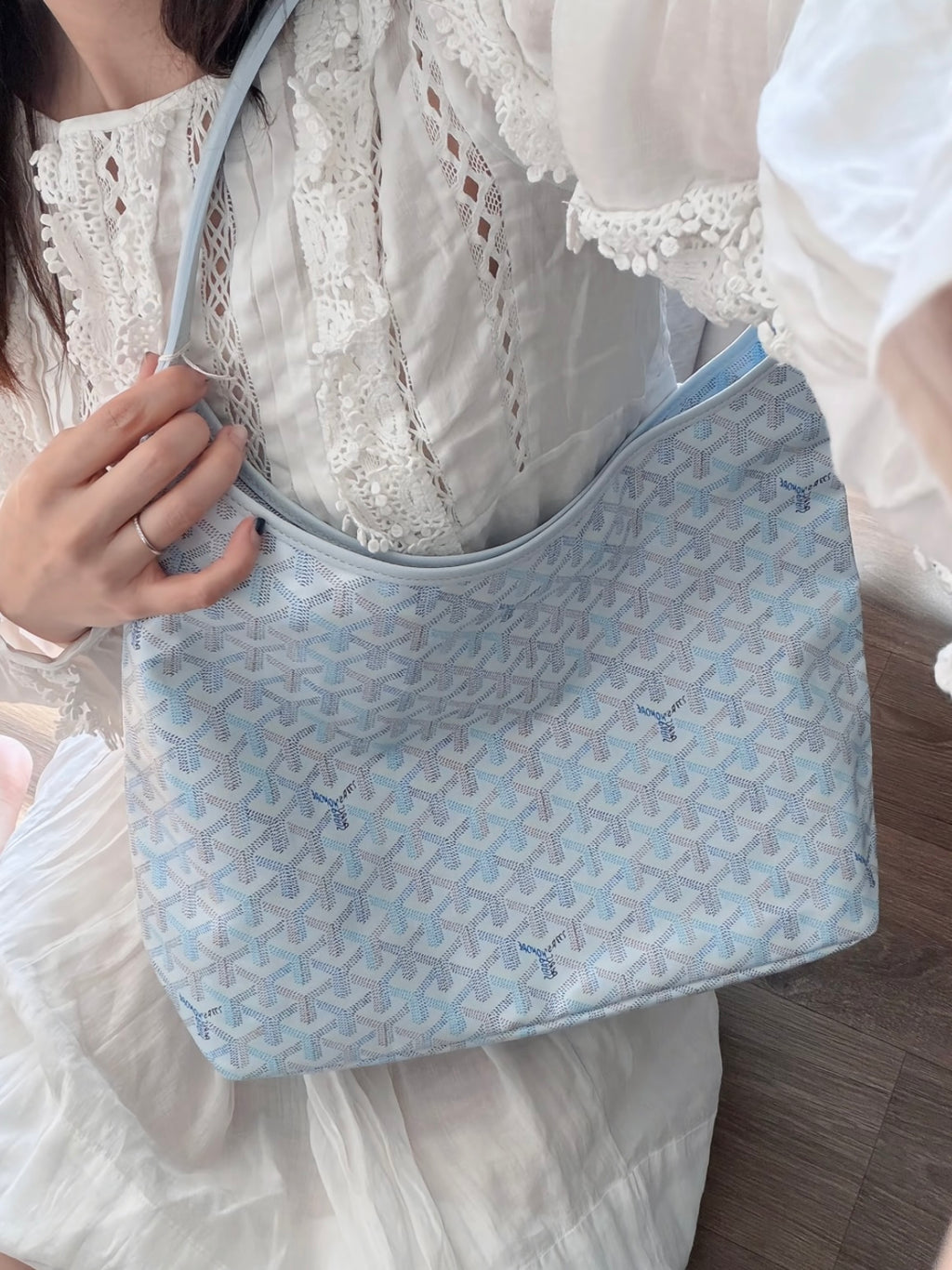 Light blue patterned shoulder tote with wide strap and zip-top closure