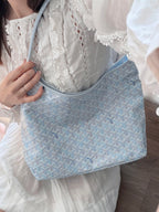Light blue patterned shoulder tote with wide strap and zip-top closure