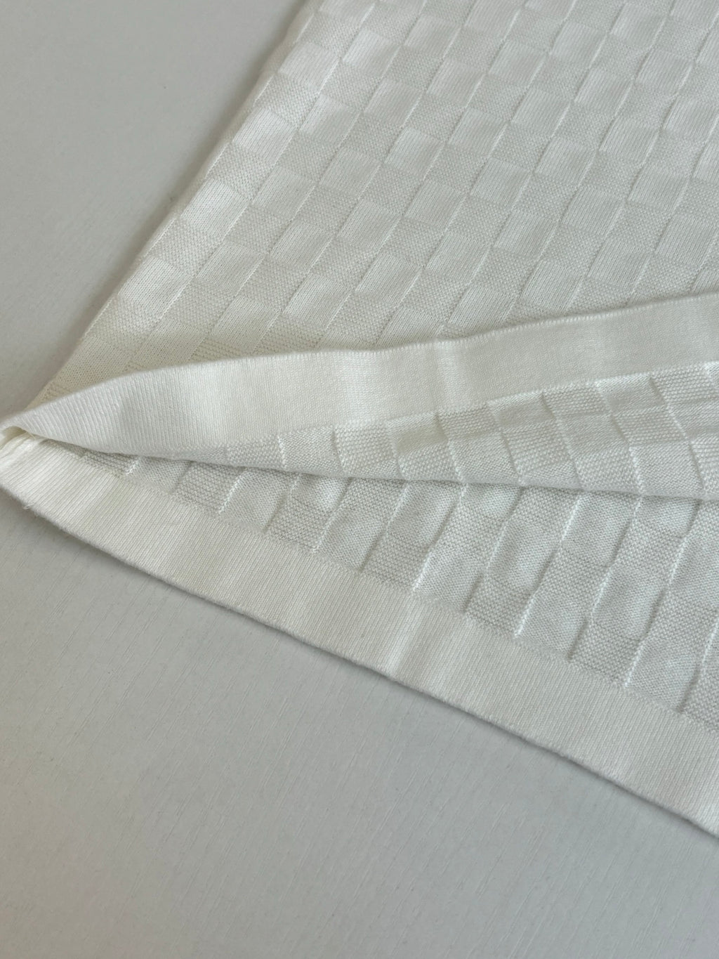 White textured polo fabric with folded cuff and hem detail