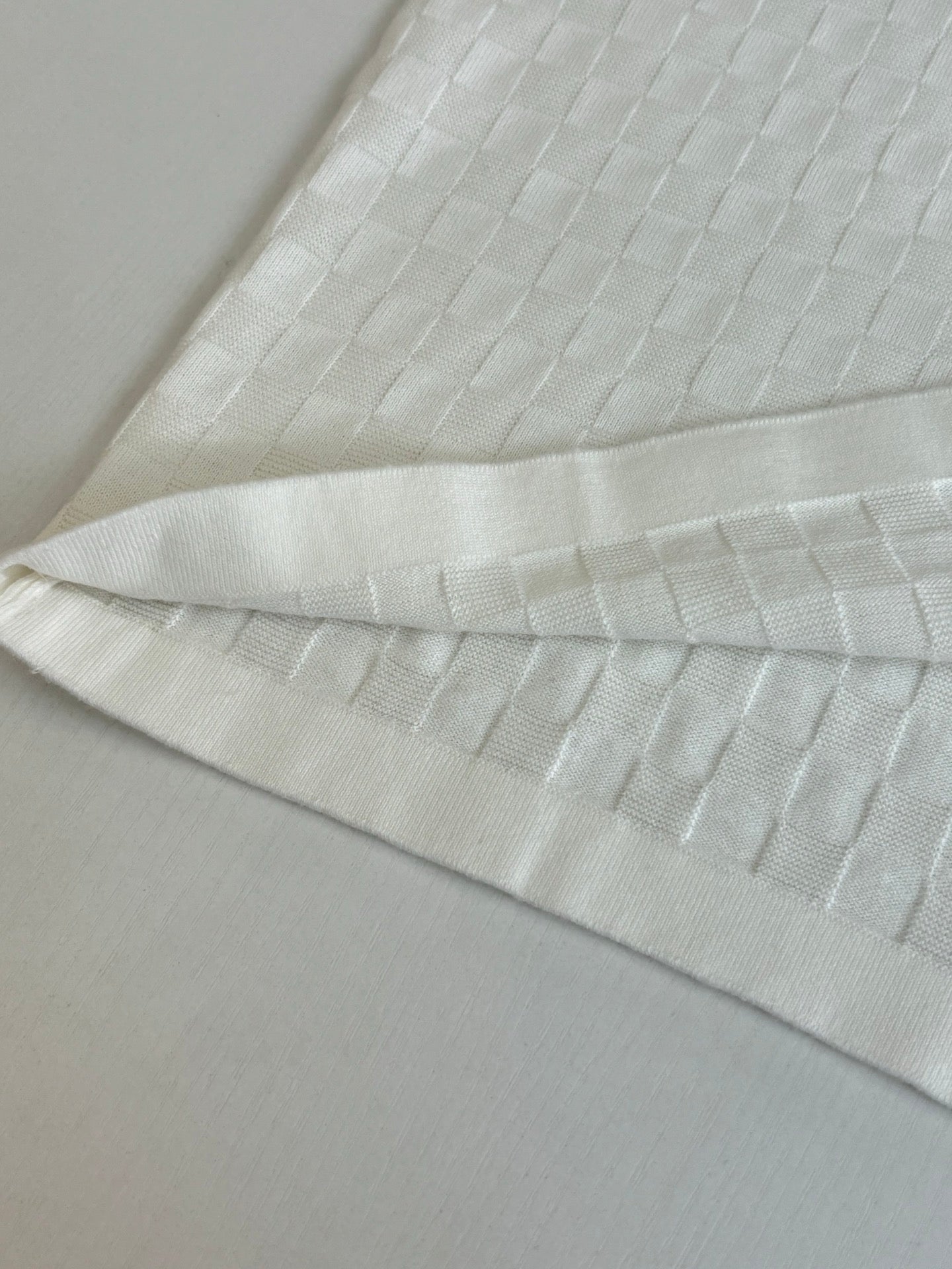 White textured polo fabric with folded cuff and hem detail