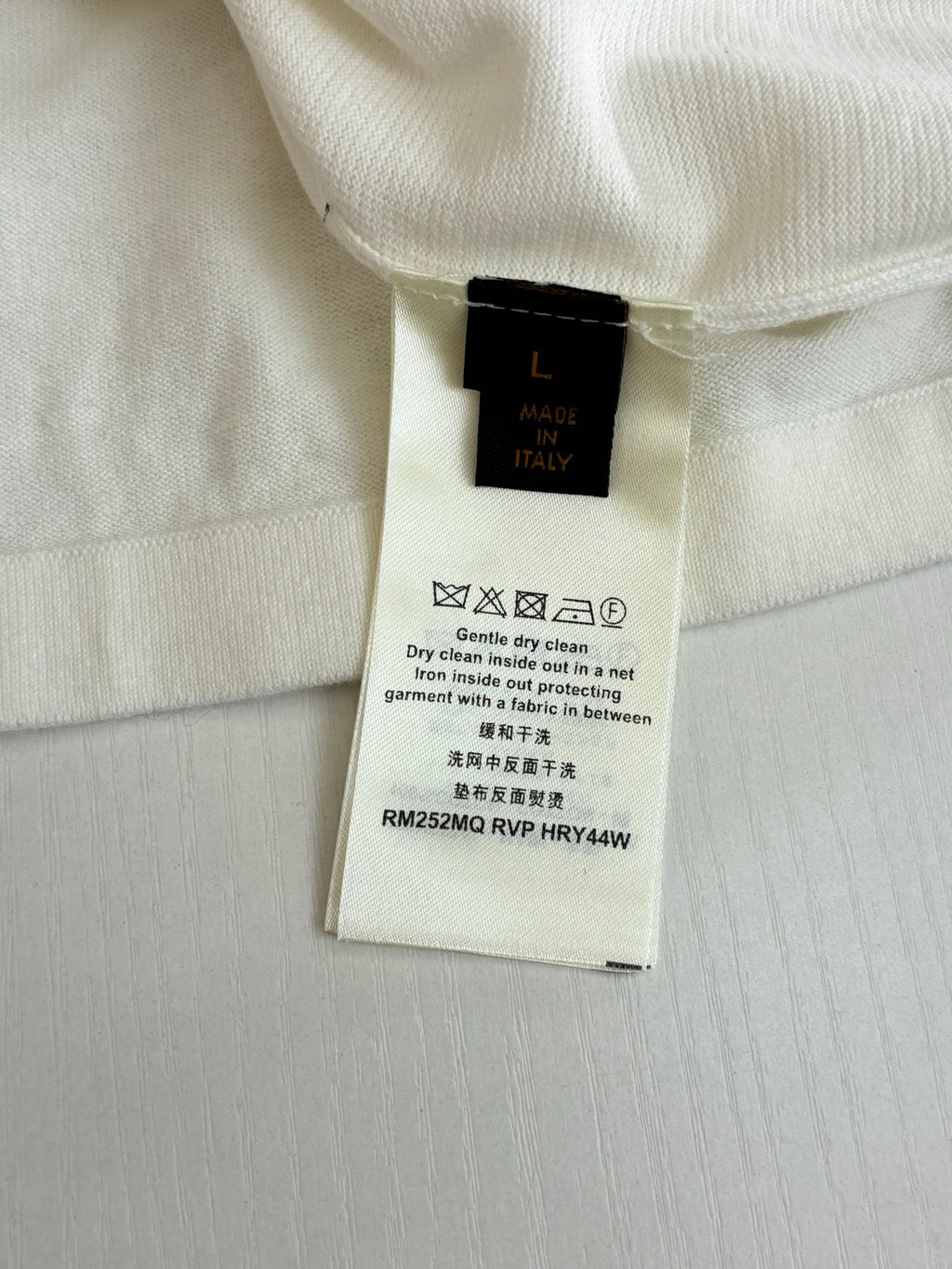 Louis Vuitton size and care label on a white polo shirt