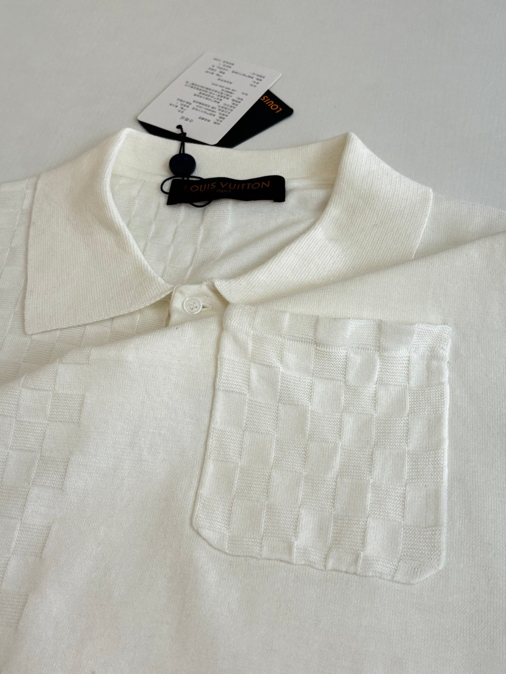 White polo shirt with textured fabric, spread collar, and chest pocket