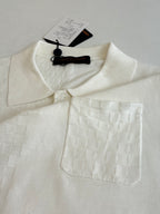 White polo shirt with textured fabric, spread collar, and chest pocket