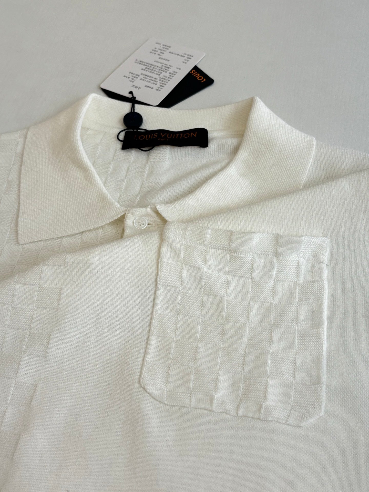 White polo shirt with textured fabric, spread collar, and chest pocket