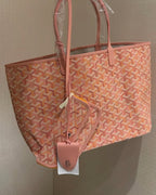 Pink patterned tote bag with top handles and hanging tag, angled view.