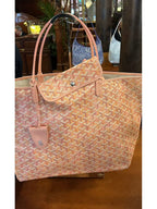 Pink patterned tote bag with top handles and front flap pouch detail, front view.
