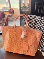 Pink patterned large tote bag with small charm and detachable key pouch, side view.