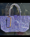 Blue patterned tote bag with top handles, front pocket, and hanging plush charm