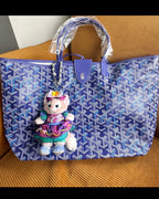 Blue patterned tote bag with top handles and a hanging doll plush keychain