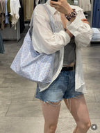 Light blue patterned hobo tote bag with curved shape and zip-top closure