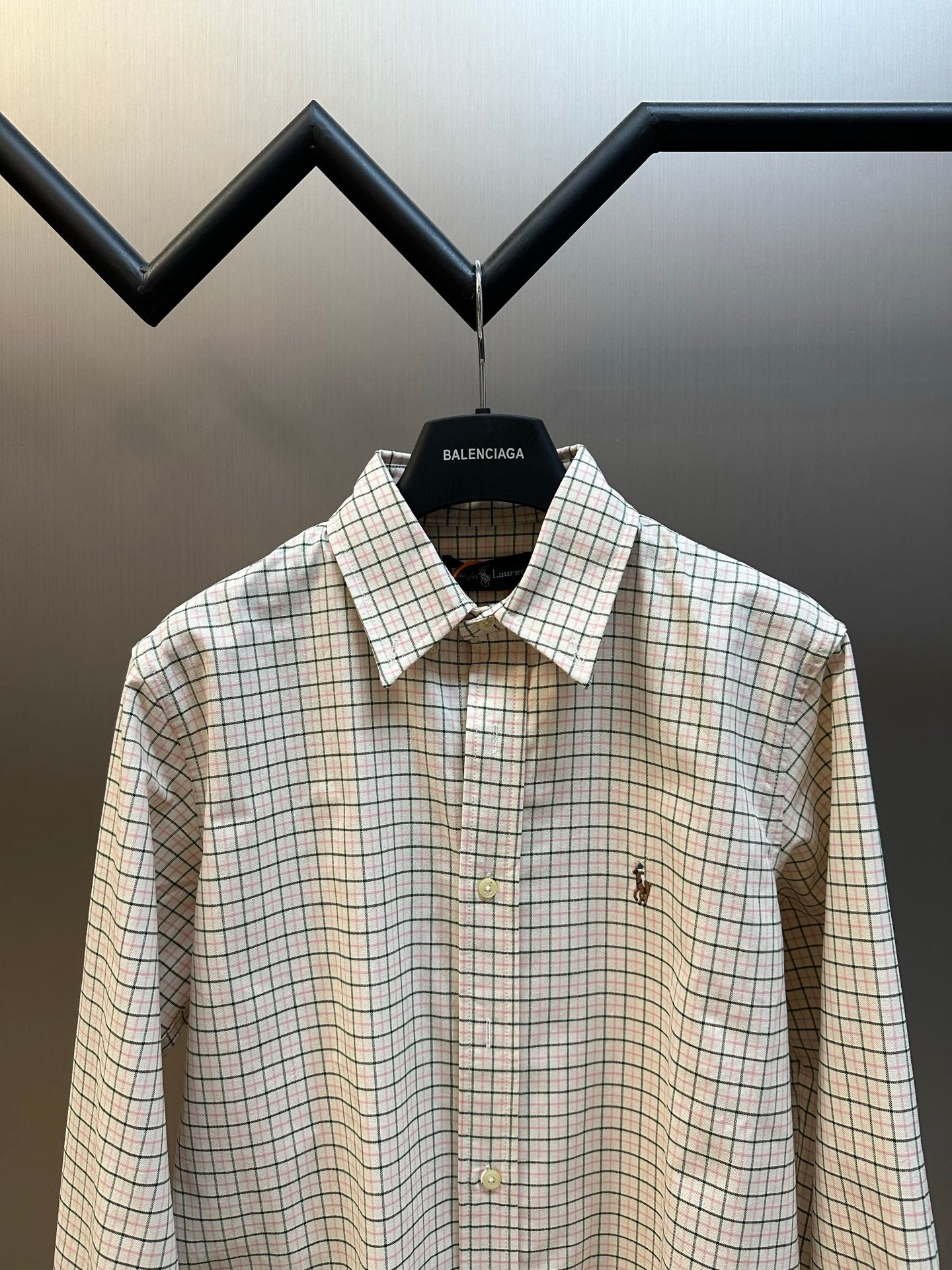 Plaid button-up shirt with spread collar and small embroidered chest accents.
