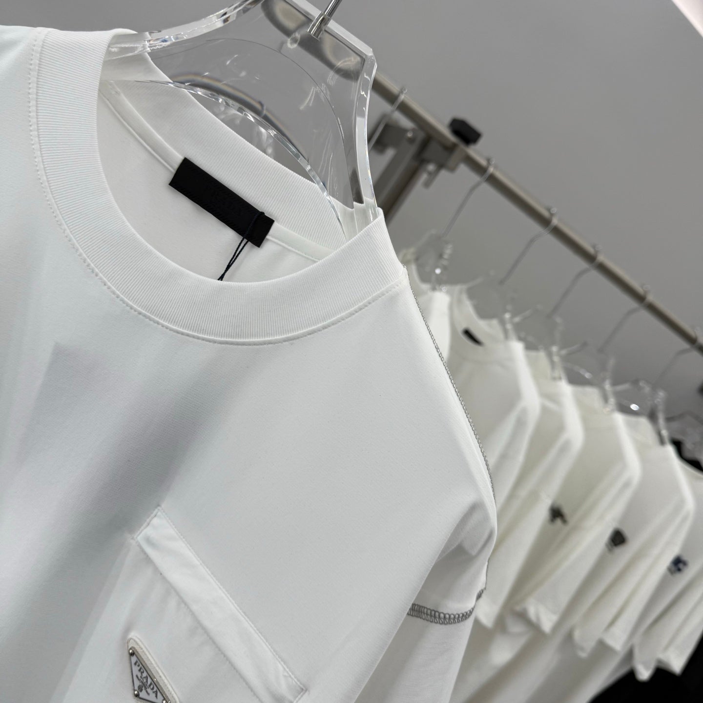 White crewneck T-shirt neckline with black label and small chest pocket
