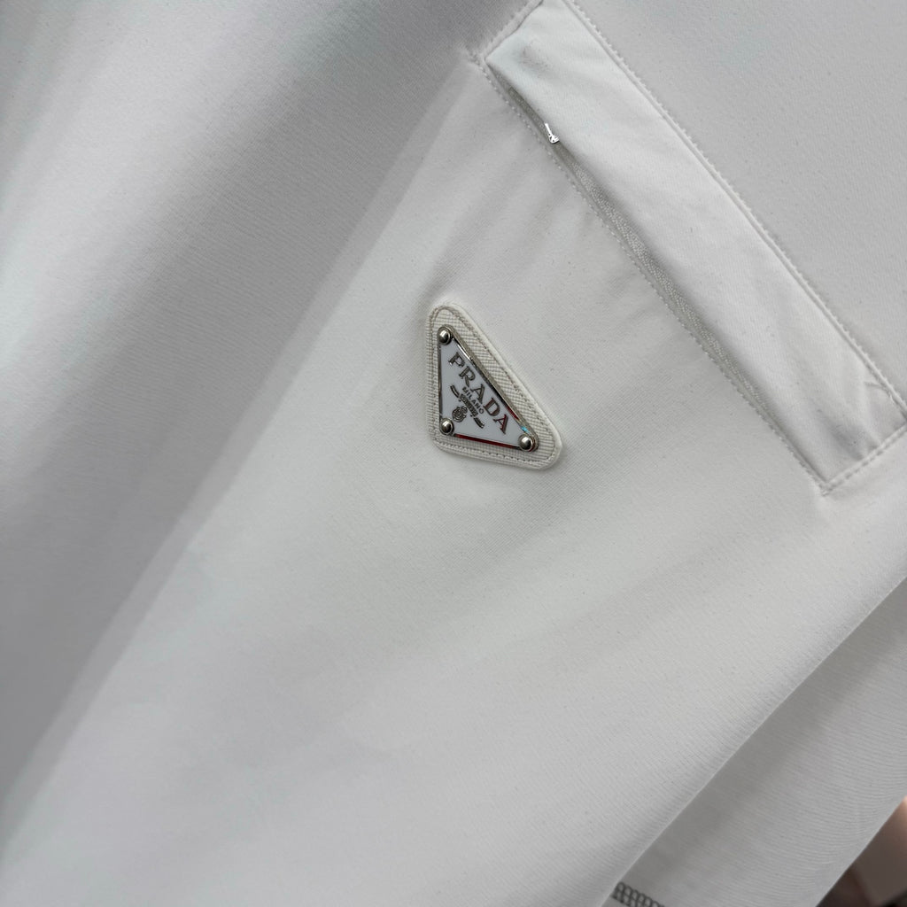 White T-shirt chest pocket with metal logo patch reading PRADA