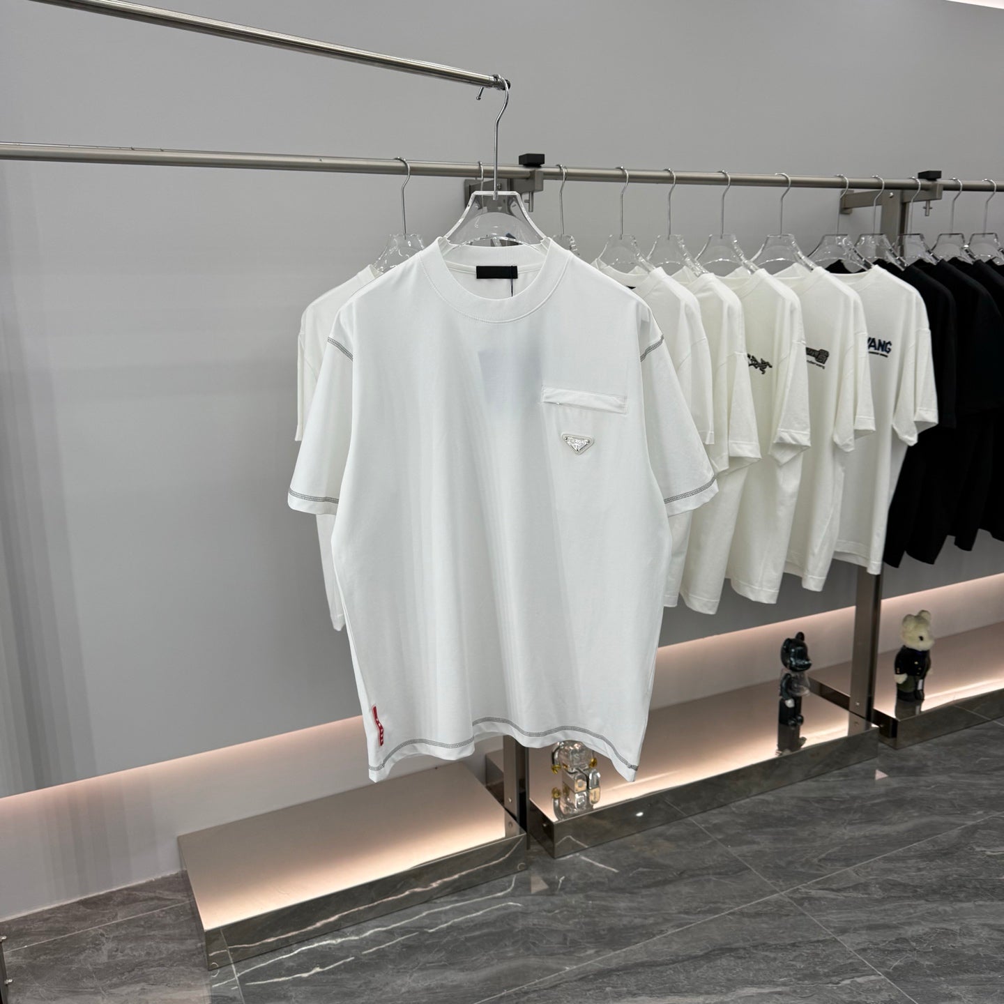 White short-sleeve T-shirt with crew neck and chest pocket on a display hanger