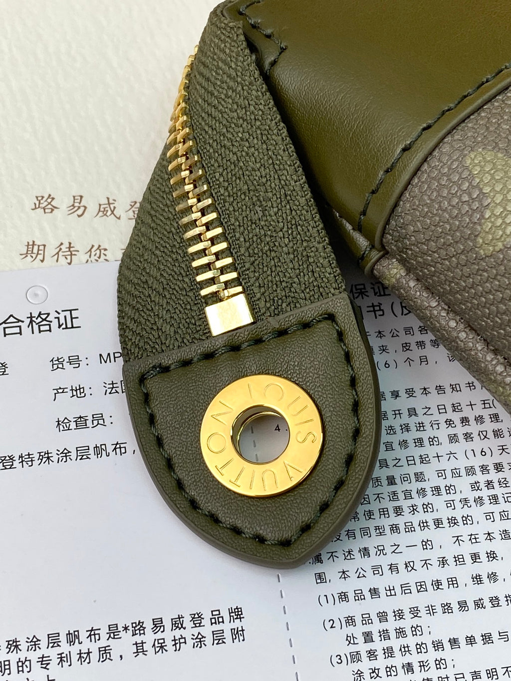 Louis Vuitton small bag front panel with green leather, circular gold snap and stitched edge