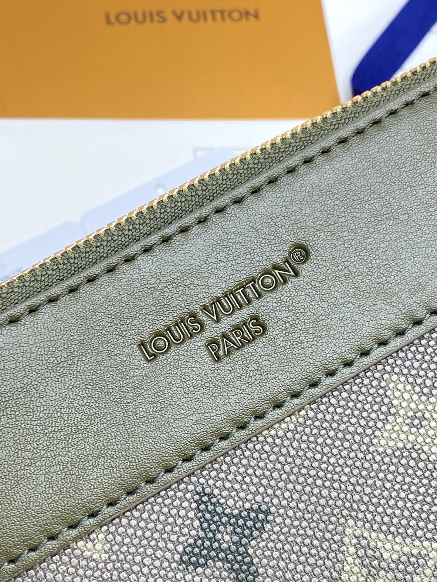 Louis Vuitton monogram bag close-up of embossed brand name and stitched trim