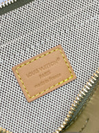 Louis Vuitton monogram bag close-up of leather logo patch and gold zipper