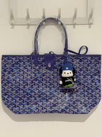 Blue patterned tote bag with two top handles and a hanging plush doll keychain