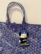 Blue patterned tote bag with leather handles and a hanging plush charm