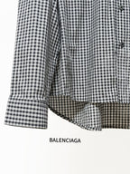 Checkered button-up shirt sleeve with buttoned cuff and rounded curved hem