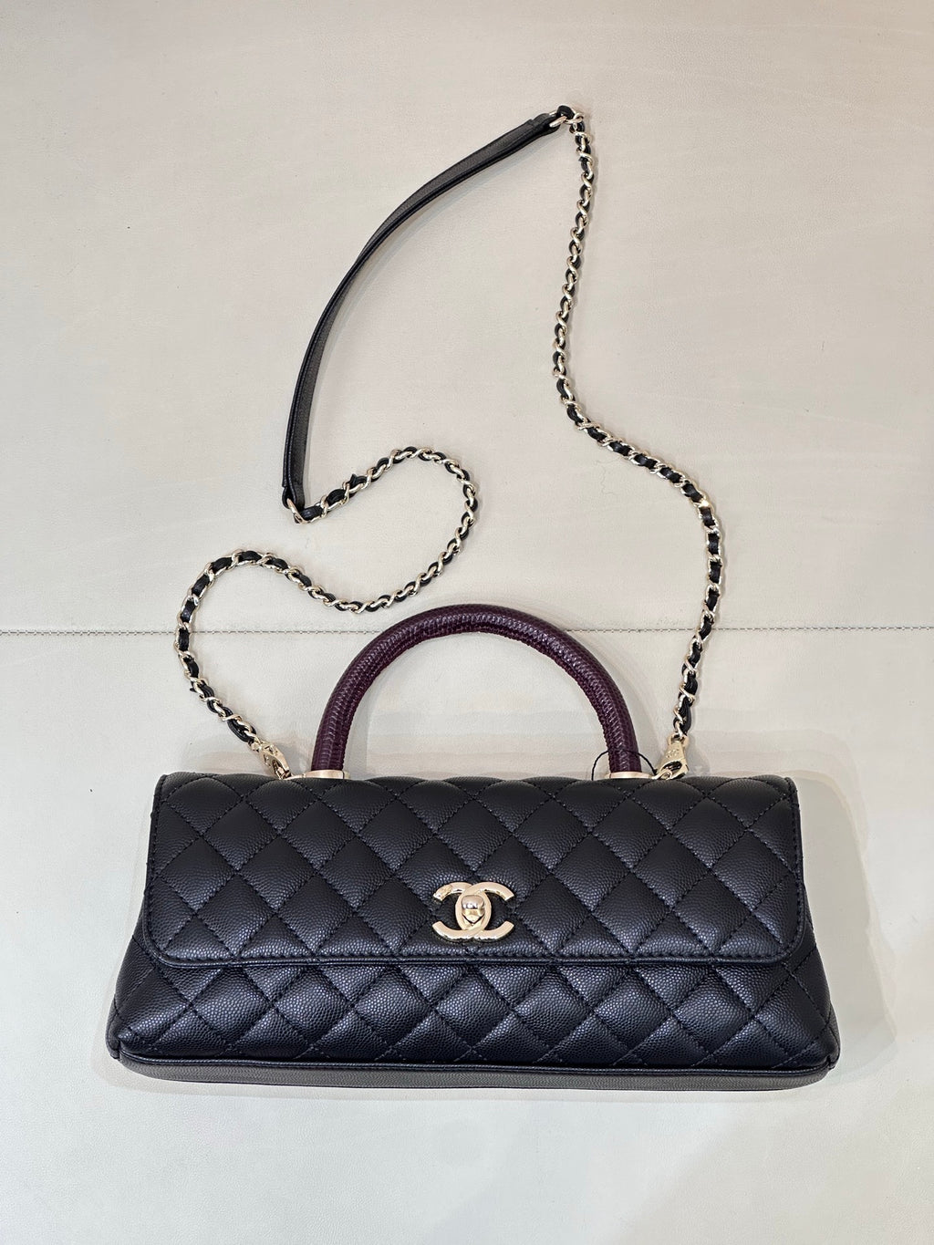 Chanel bag in dark navy quilted leather with purple top handle and chain shoulder strap