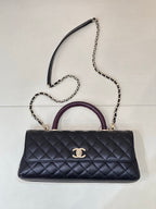 Chanel bag in dark navy quilted leather with purple top handle and chain shoulder strap