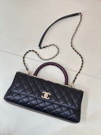 Chanel bag in dark navy quilted leather with gold CC logo, purple handle and chain strap