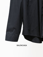 Dark long-sleeve shirt with mid-length hem and folded sleeve cuffs