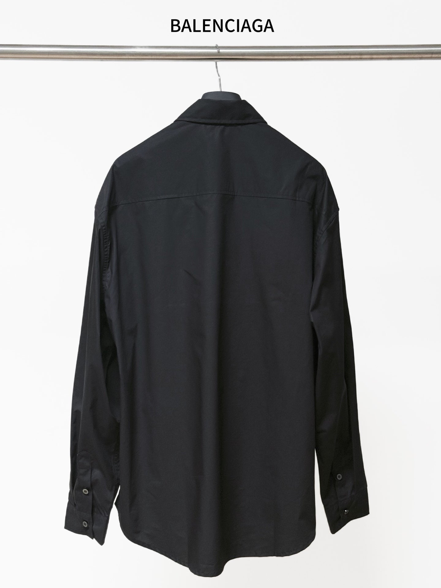 Dark long-sleeve button-up shirt, back view, button cuffs