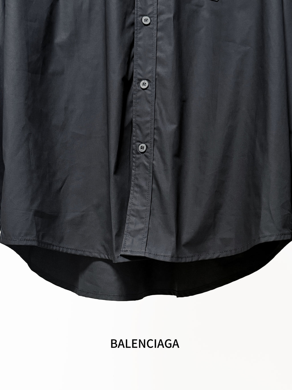 Dark long-sleeve shirt hem with curved back and button details