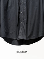 Dark long-sleeve shirt hem with curved back and button details