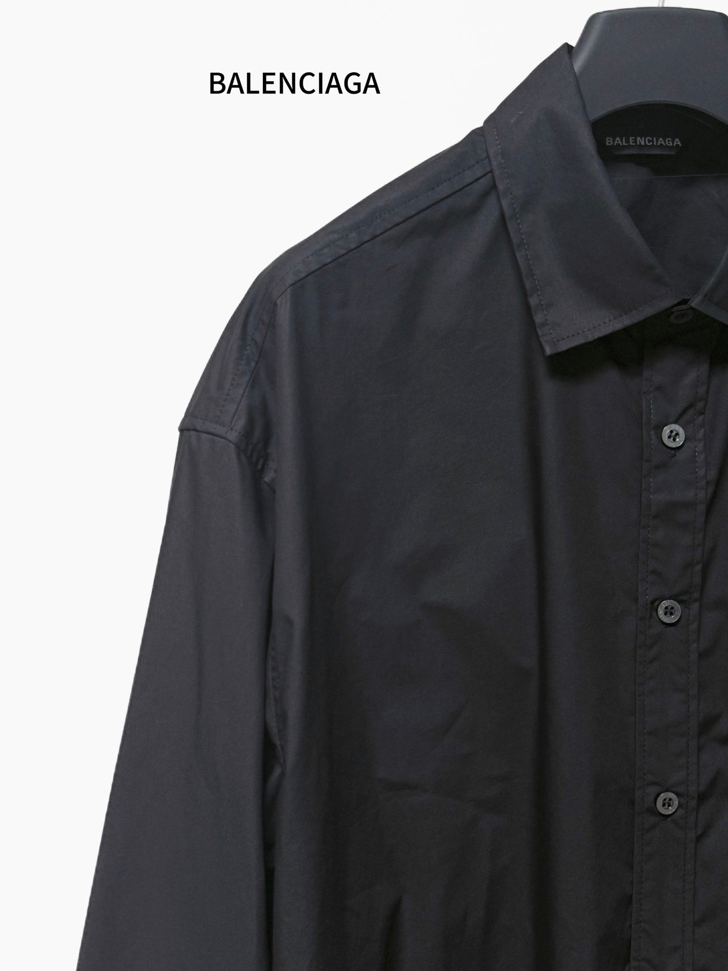 Dark long-sleeve button-up shirt close-up, point collar and button placket