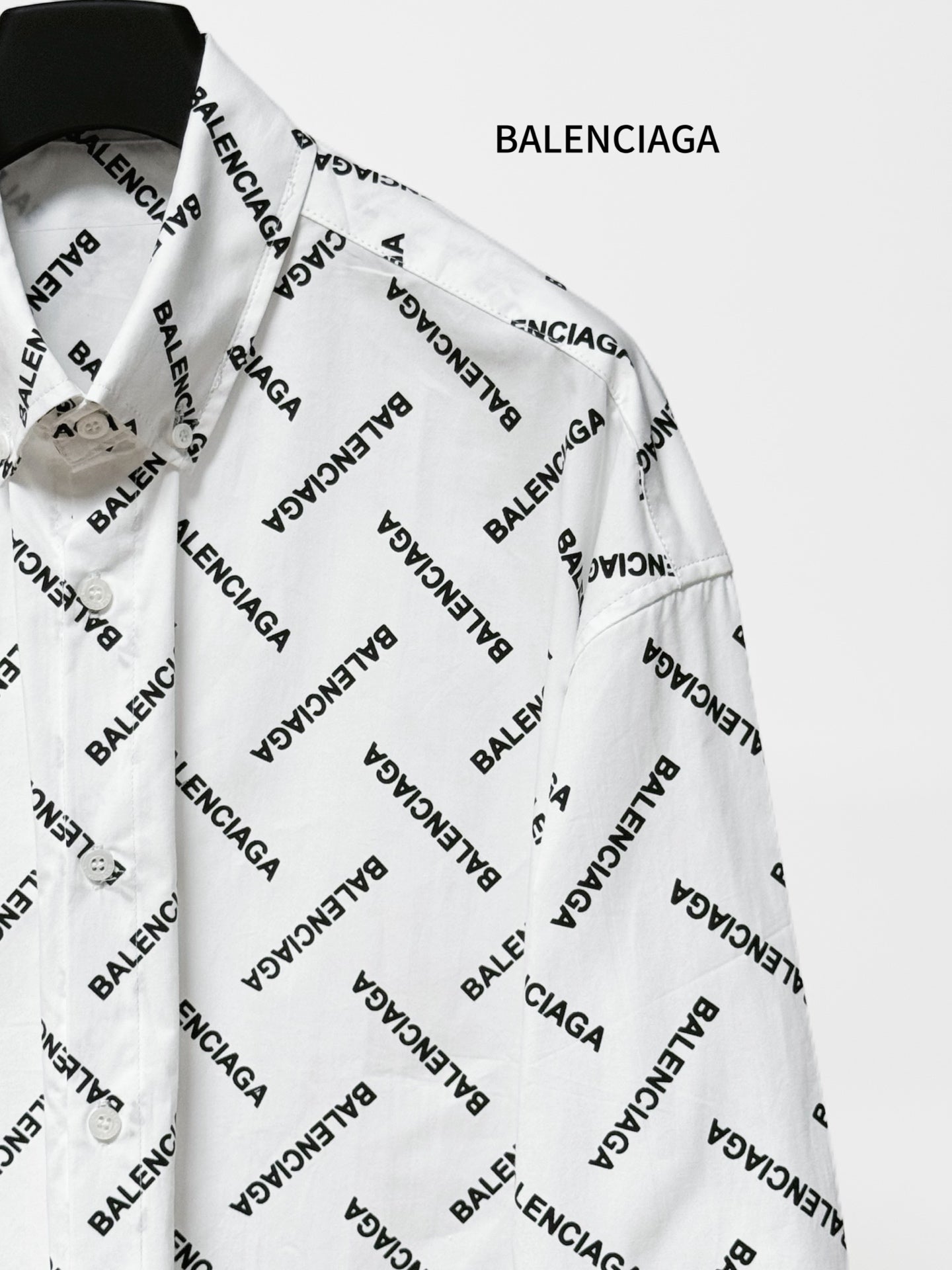 White long-sleeve button-up shirt with black Balenciaga logo print, side view