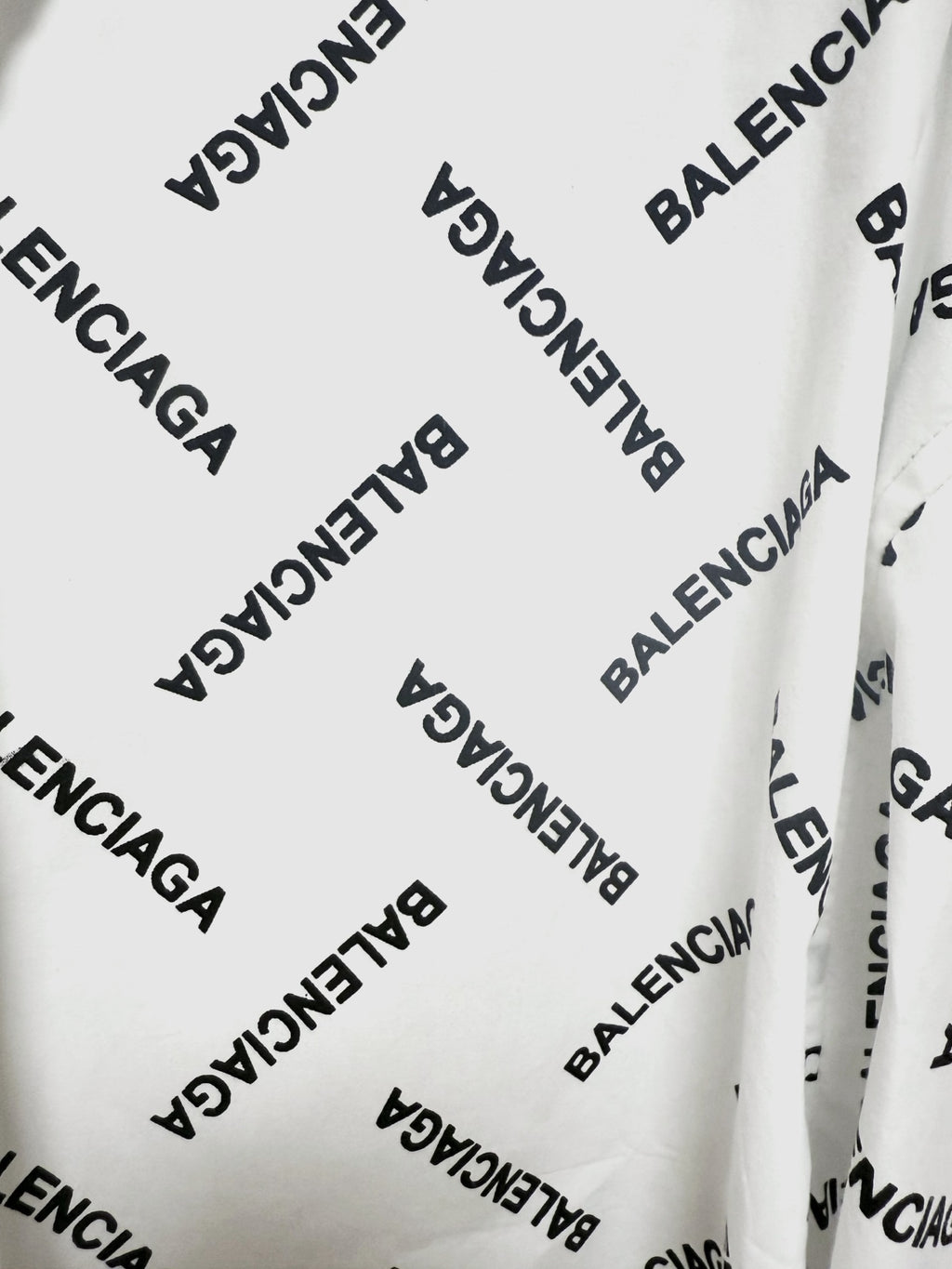 White long-sleeve button-up shirt fabric detail with black Balenciaga logo print
