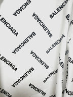 White long-sleeve button-up shirt fabric detail with black Balenciaga logo print