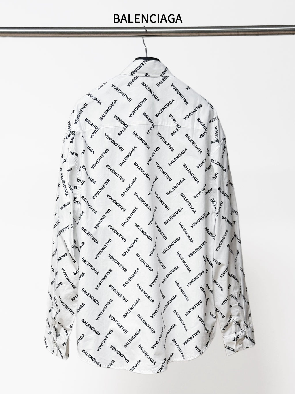 White long-sleeve button-up shirt, back view, with black Balenciaga logo allover print