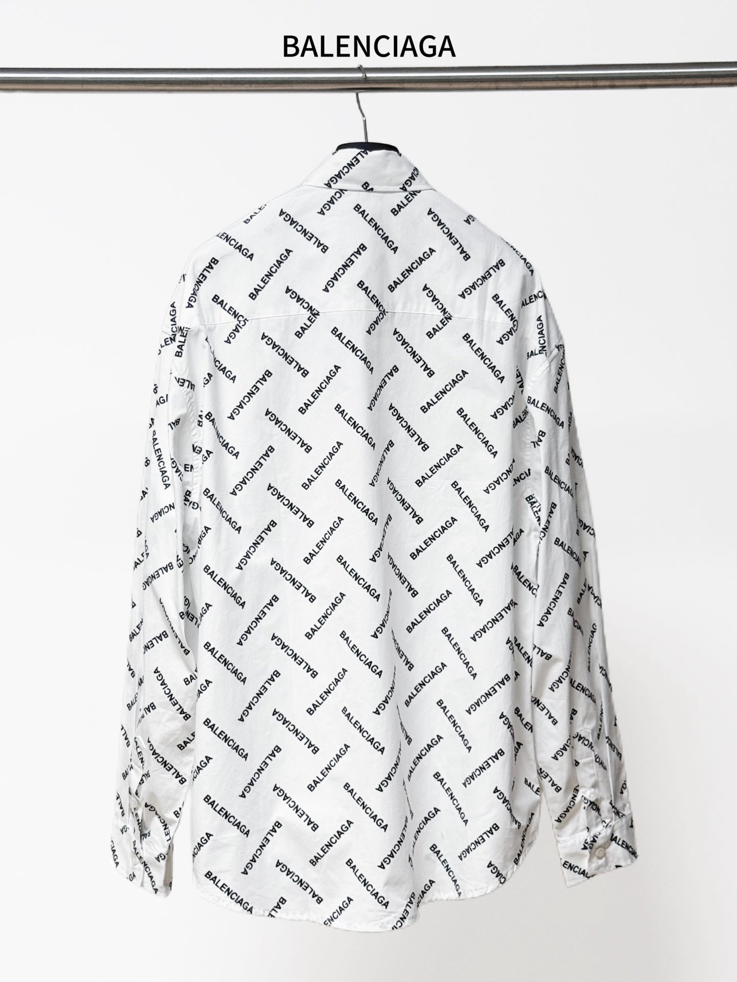 White long-sleeve button-up shirt, back view, with black Balenciaga logo allover print