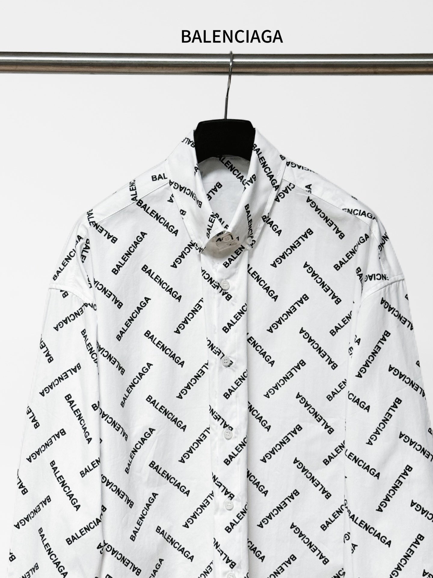 White long-sleeve button-up shirt with black Balenciaga logo print, front view