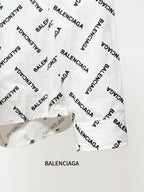 White long-sleeve button-up shirt hem with black Balenciaga logo print detail