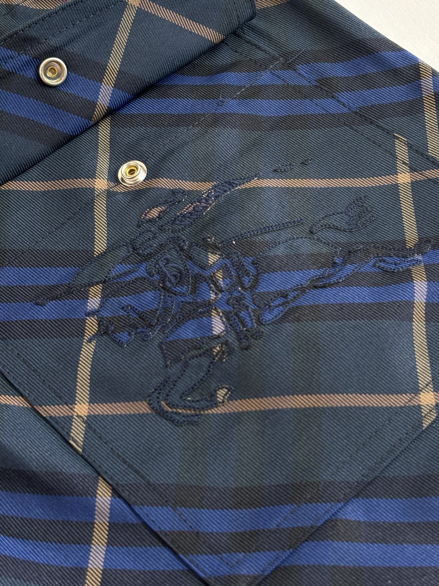 Navy plaid shorts embroidered patch detail on front panel, blue and tan grid
