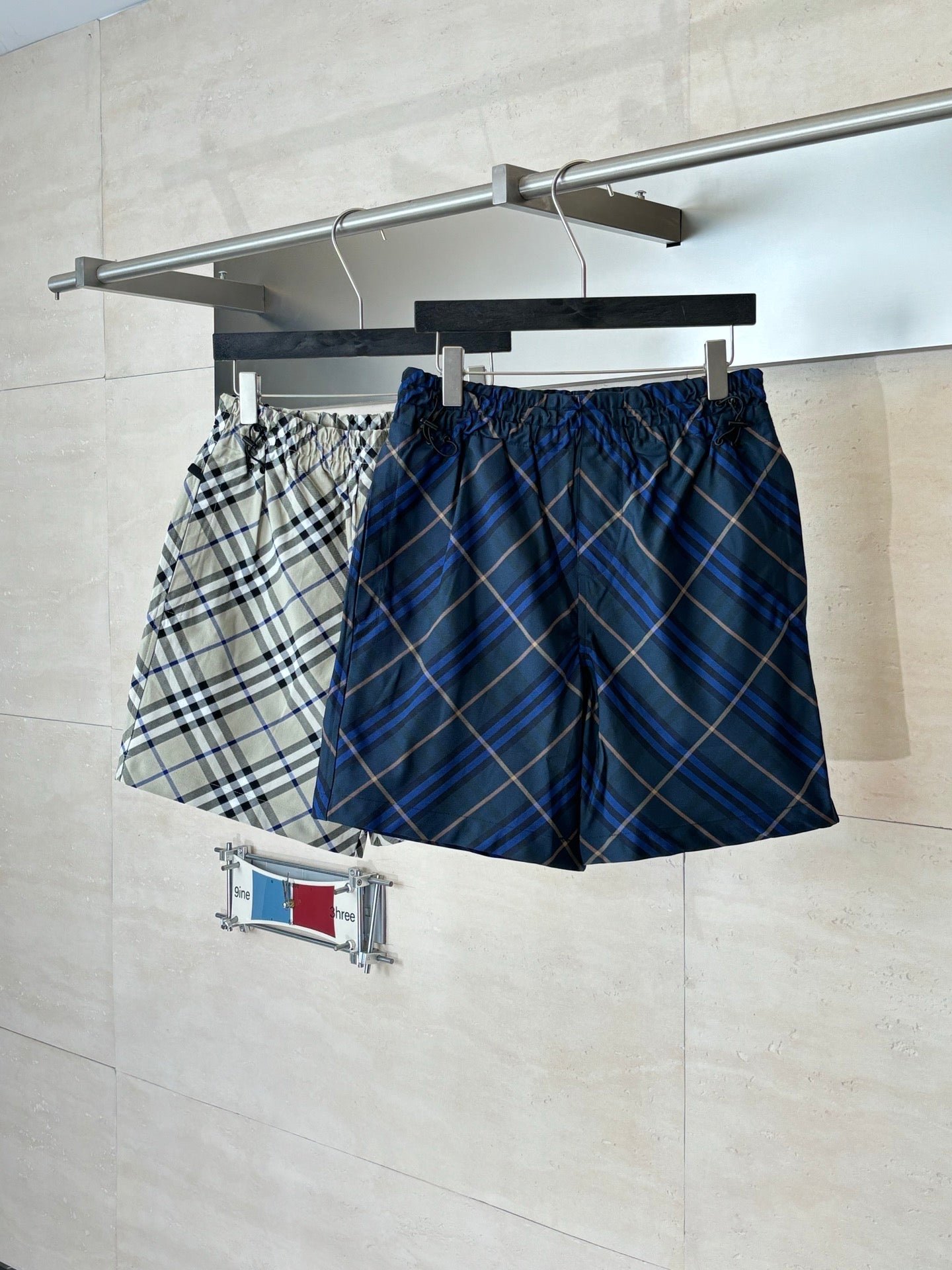 Navy plaid shorts on hanger, elastic waistband with gathered front