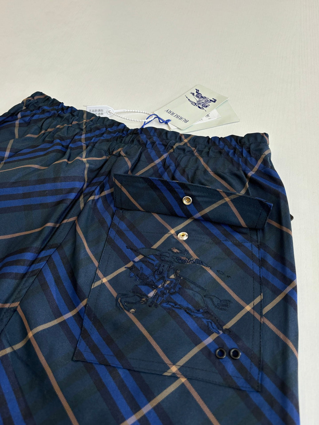 Navy plaid shorts front with button placket and gathered elastic waistband
