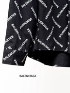 Black long-sleeve shirt with Balenciaga logo pattern, cropped view of sleeves and hem
