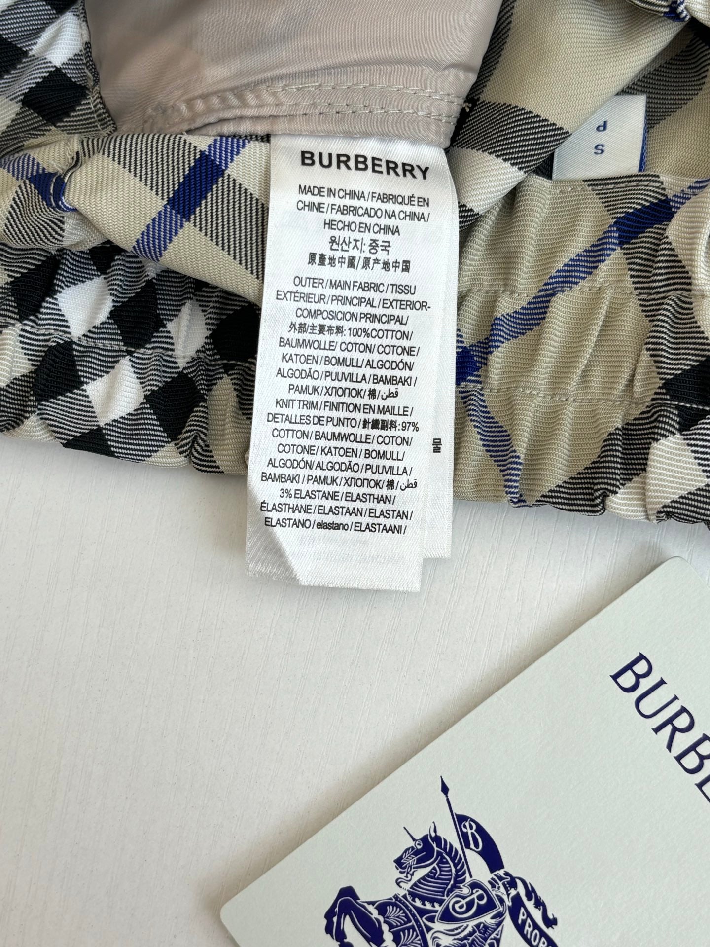 Checked pants garment tag and care label on waistband, blue black and cream pattern