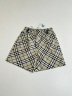 Plaid pants laid flat, gathered elastic waistband with drawstring, beige blue and black checks