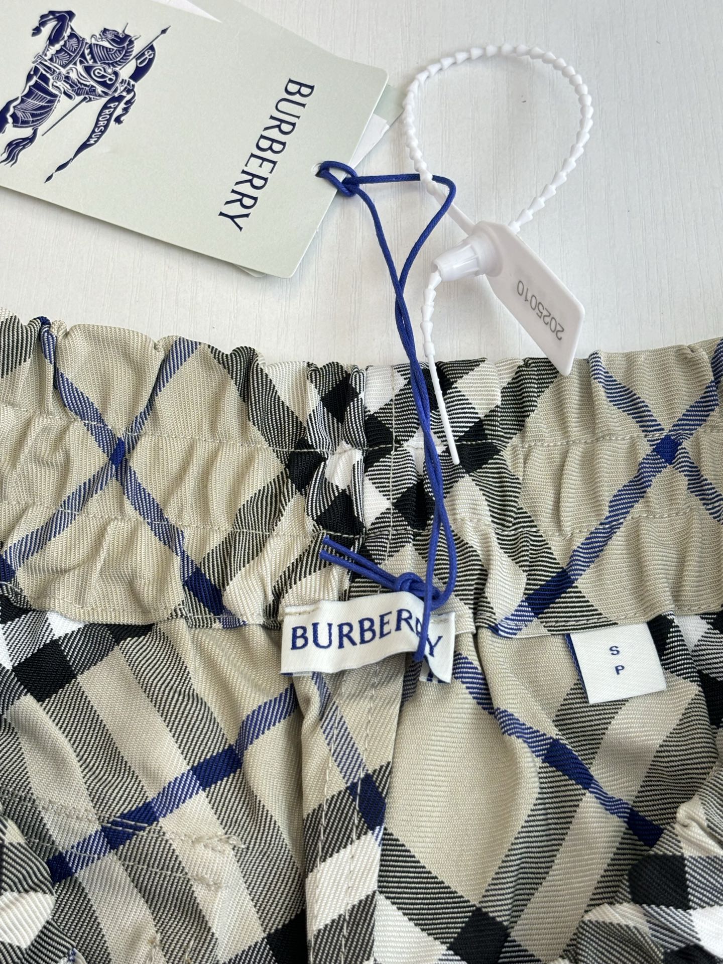 Kids checked pants with elastic waistband and blue drawstring tie, cream blue black