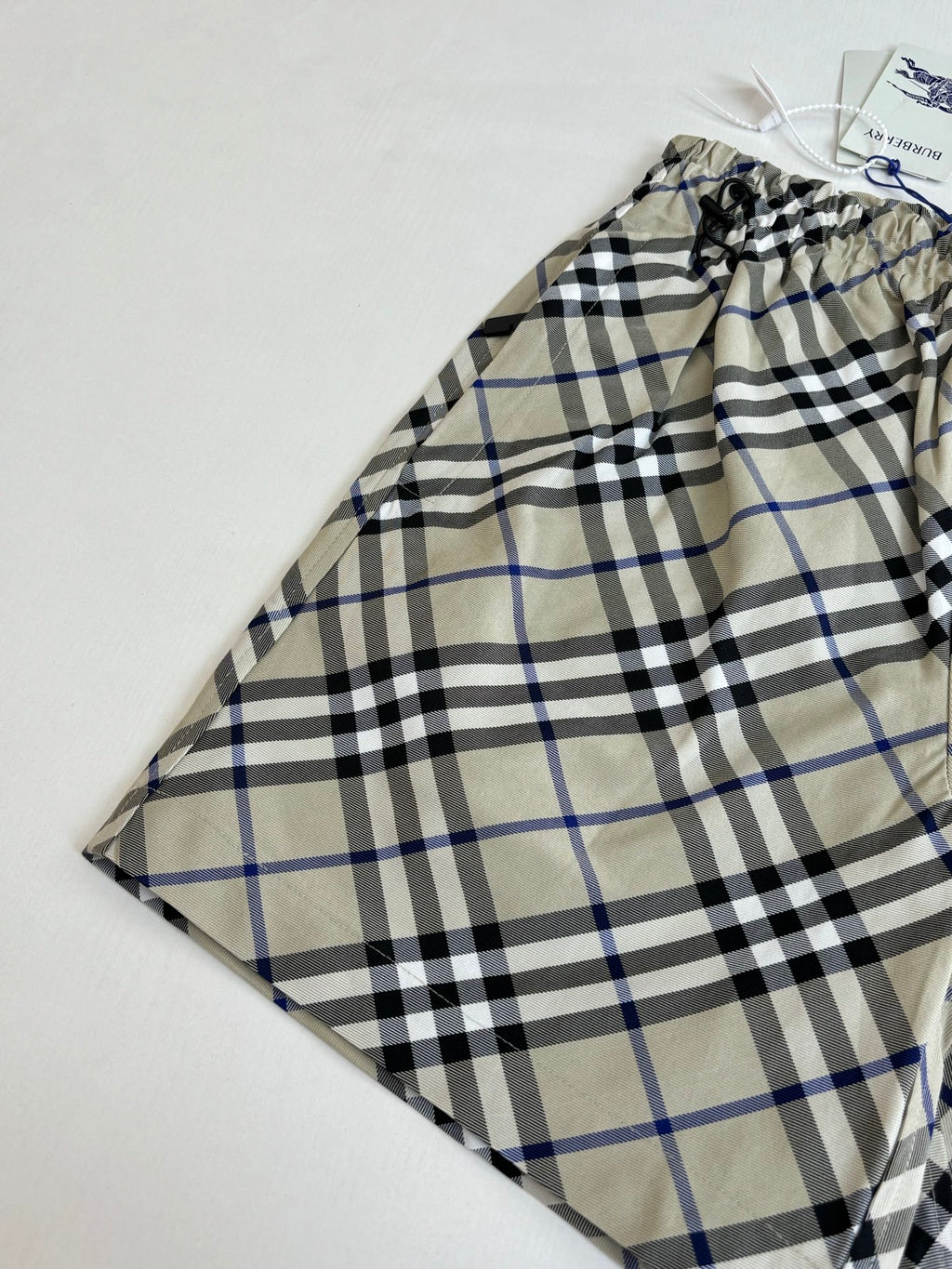Plaid pants with drawstring waist, beige blue and black checks, laid flat with tag