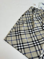 Plaid pants with drawstring waist, beige blue and black checks, laid flat with tag